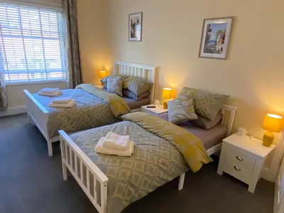 a bedroom with two beds and a couch at Brooklands Guest House in Llandrindod Wells