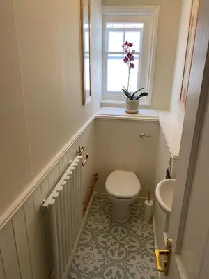 a small bathroom with a toilet and a window at Brooklands Guest House in Llandrindod Wells
