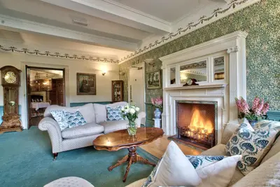 a living room with a couch and a fireplace at Caer Beris Manor By Group Retreats in Builth Wells