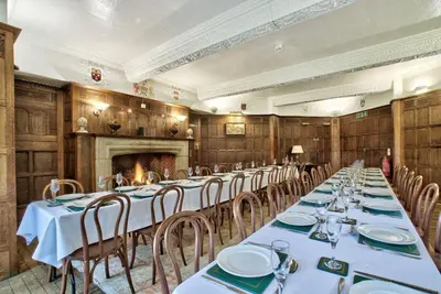a dining room with tables and chairs and a fireplace at Caer Beris Manor By Group Retreats in Builth Wells