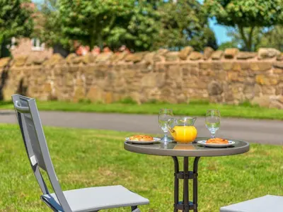 a table with two glasses of orange juice and two chairs at Hidden Gem in Stunning Location - Pass the Keys in Cressage