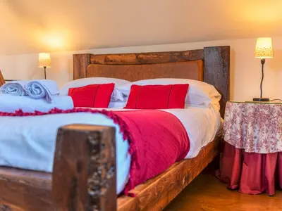 a bedroom with a large wooden bed with red pillows at Hidden Gem in Stunning Location - Pass the Keys in Cressage