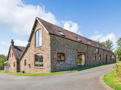 an old stone building with windows on a road at Hidden Gem in Stunning Location - Pass the Keys in Cressage