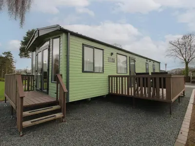 a green tiny house with a large deck at Heron in Leominster