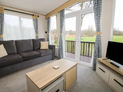 a living room with a couch and a tv at Heron in Leominster