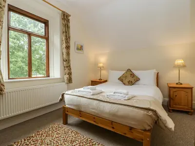 a bedroom with a bed and a window at Keepers Cottage in Leominster