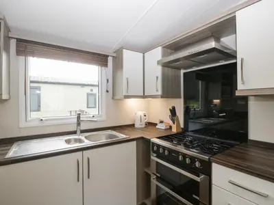a kitchen with a sink and a stove top oven at Swan in Leominster