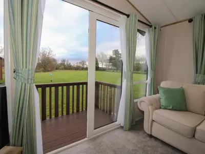 a living room with a sliding glass door to a deck at Owl in Leominster