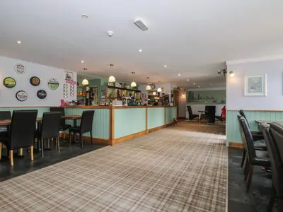 a restaurant with a bar and a table and chairs at Owl in Leominster