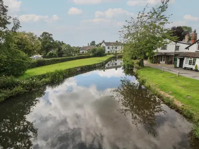 a river in a town with houses and trees at Foxglove in Leominster