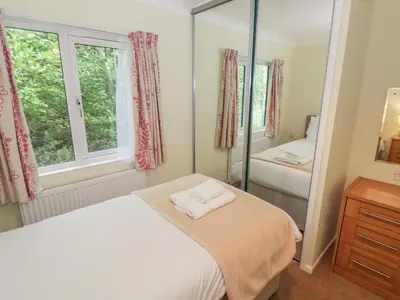 a bedroom with a bed and a mirror at Daffodil in Leominster
