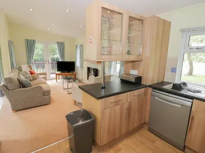 a kitchen and living room with a couch and a table at Daffodil in Leominster