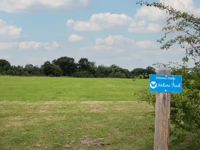 a blue sign on a wooden pole in a field at Daffodil in Leominster