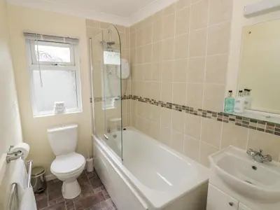 a bathroom with a toilet and a tub and a sink at Daffodil in Leominster