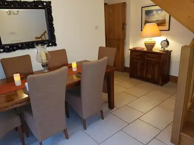 a dining room with a table and chairs and a mirror at River Cottage Brecon: Hot Tub, Fire, Balcony, Wifi in Brecon