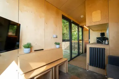 a tiny house with a kitchen and a living room at Beautiful cabins in Herefordshire countryside in Hereford