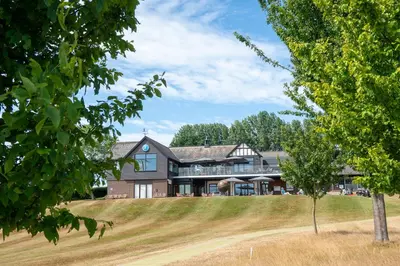 a large house on a hill with a tree at Beautiful cabins in Herefordshire countryside in Hereford