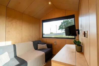 a small living room with a couch and a window at Beautiful cabins in Herefordshire countryside in Hereford
