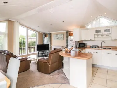 a kitchen with a counter and a living room at Daisy in Leominster