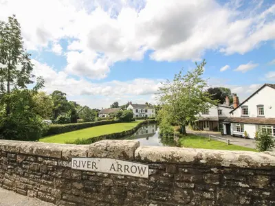 a river arrow sign on a stone wall in a village at Daisy in Leominster