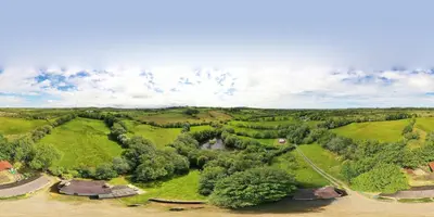 an aerial view of a farm with trees and a river at Converted Granary on a rural small holding in Cross Inn