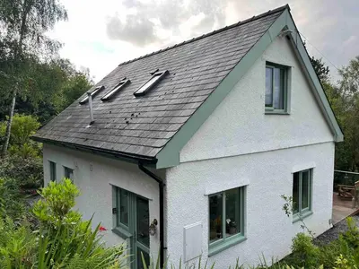 a white house with a gray roof and windows at Erw Fair in Arthog