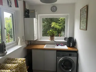 a kitchen with a washing machine and a window at Erw Fair in Arthog