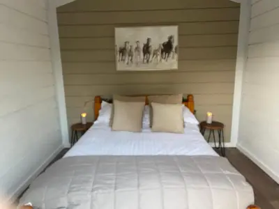 a bedroom with a white bed with two candles at The Haystack in Oswestry