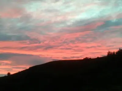 a sunset over a hill with a red sky at Stargazing lodge with amazing views. in Llandrindod Wells