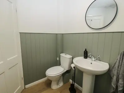 a bathroom with a white toilet and a sink at Bluebell's Cottage in Shrewsbury