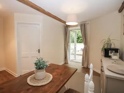 a living room with a table and a sink at Bluebell's Cottage in Shrewsbury
