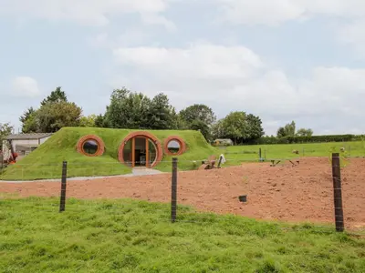 a house with a grass roof in a field at Shire's End in Caynham