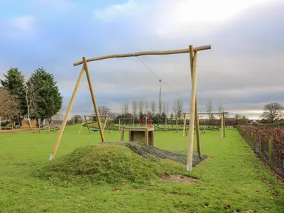 a playground with a swing set in a park at Dove in Leominster