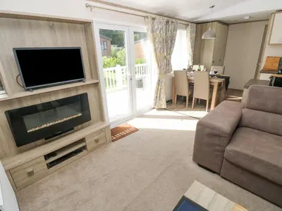 a living room with a flat screen tv and a couch at 116 Woodpecker Lodge in New Quay
