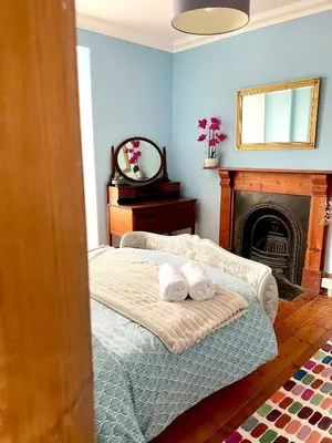 a bedroom with a bed and a fireplace with two towels at Rhianfa 4 bedroom house minutes walk from the beach in New Quay
