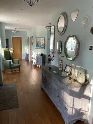 a living room with a dresser and mirrors on the wall at The Old Coach House in Llangollen