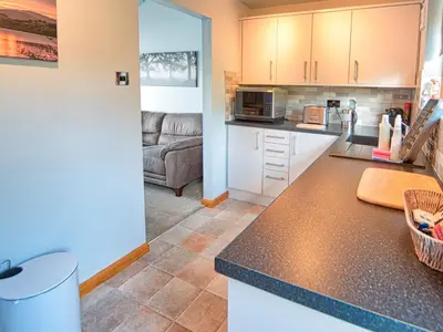 a kitchen with a counter top and a living room at Arenig - Bala Lake in Bala