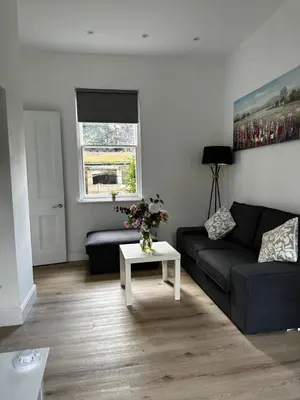 a living room with a couch and a table at Flat 2 The Butlers Quarters in Oswestry