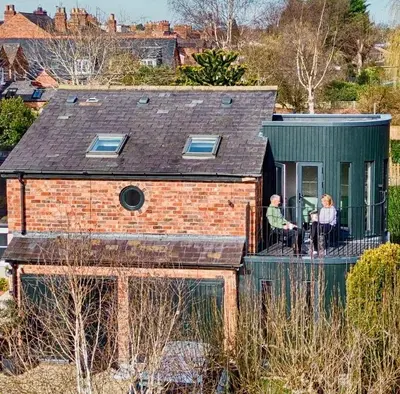 two people sitting on a balcony of a house at The Old Stables, The River Severn, Shrewsbury in Shrewsbury