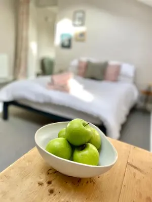 a bowl of green fruit sitting on a table at The Old Stables, The River Severn, Shrewsbury in Shrewsbury