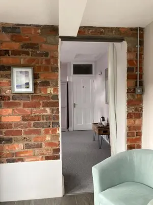a brick wall in a living room with a mirror at The Old Stables, The River Severn, Shrewsbury in Shrewsbury