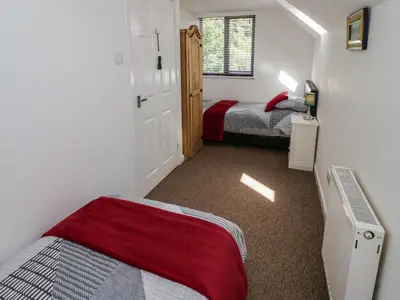 a small bedroom with two beds and a window at 3 Oaks Lodge in Shrewsbury
