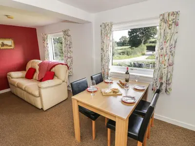 a dining room with a table and a couch at 3 Oaks Lodge in Shrewsbury