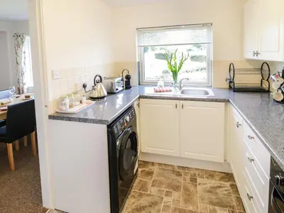 a kitchen with a washing machine and a sink at 3 Oaks Lodge in Shrewsbury
