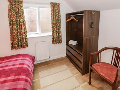a bedroom with a bed and a chair and a window at 3 Oaks Lodge in Shrewsbury