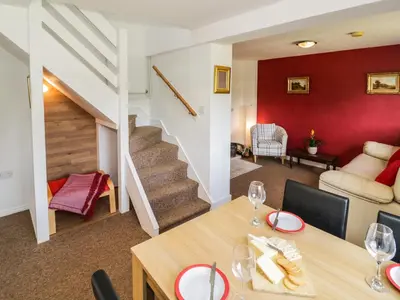 a dining room and living room with red walls and a table at 3 Oaks Lodge in Shrewsbury