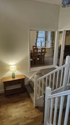a staircase with a mirror and a table with a lamp at 1 Chapel Nazareth in Penrhyndeudreath