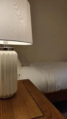 a lamp sitting on a table next to a bed at 1 Chapel Nazareth in Penrhyndeudreath