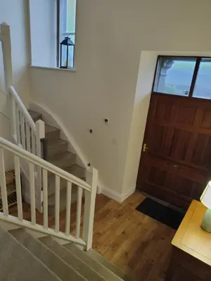 a hallway with a staircase and a wooden door at 1 Chapel Nazareth in Penrhyndeudreath