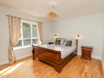 a bedroom with a bed and a window at The Coach House at Plas Dolguog in Machynlleth
